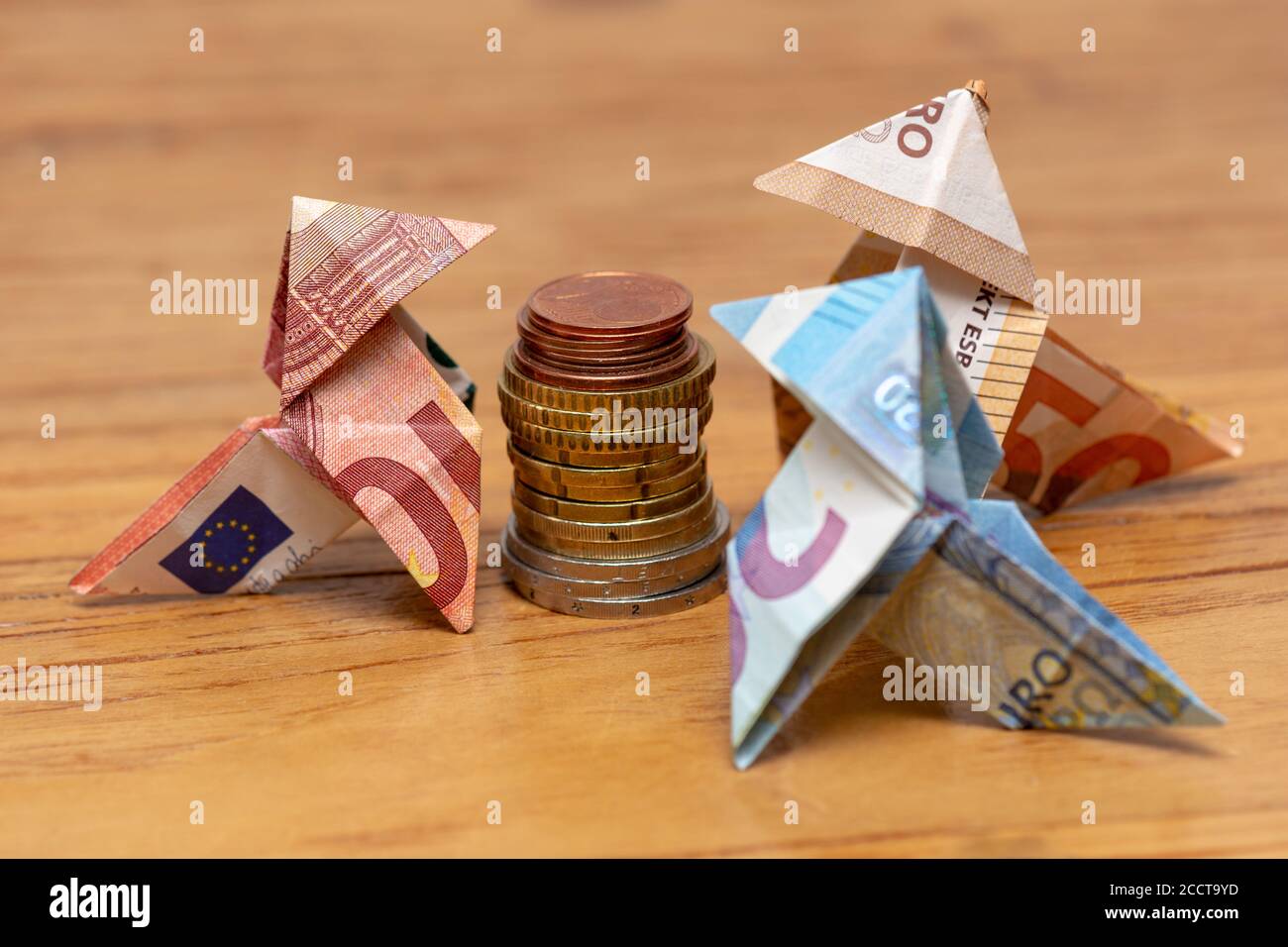 Origami birds made of 10 and 50 euro bank notes around a stack of euro  coins Stock Photo - Alamy