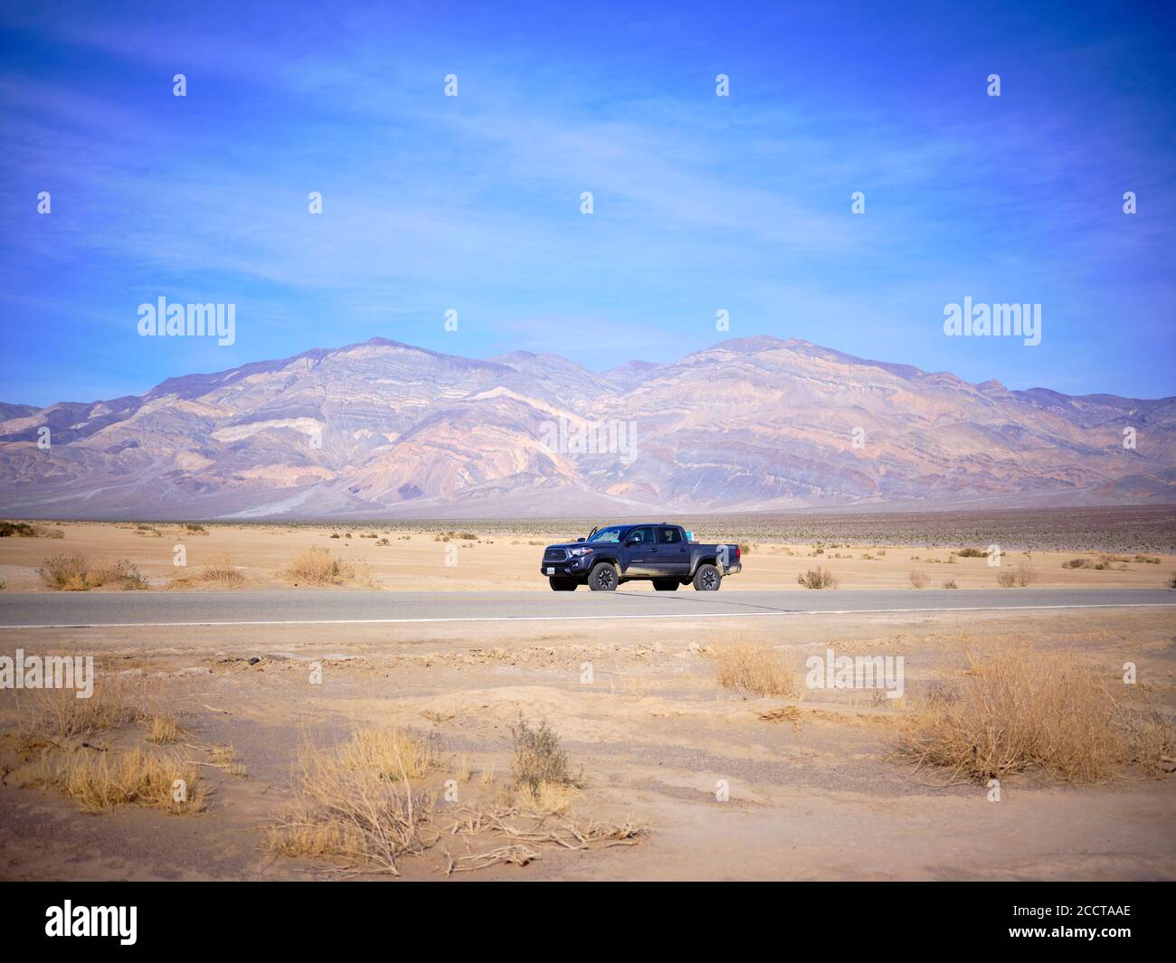 A toyota truck parked on the side of a desert highway, Death Valley. Stock Photo