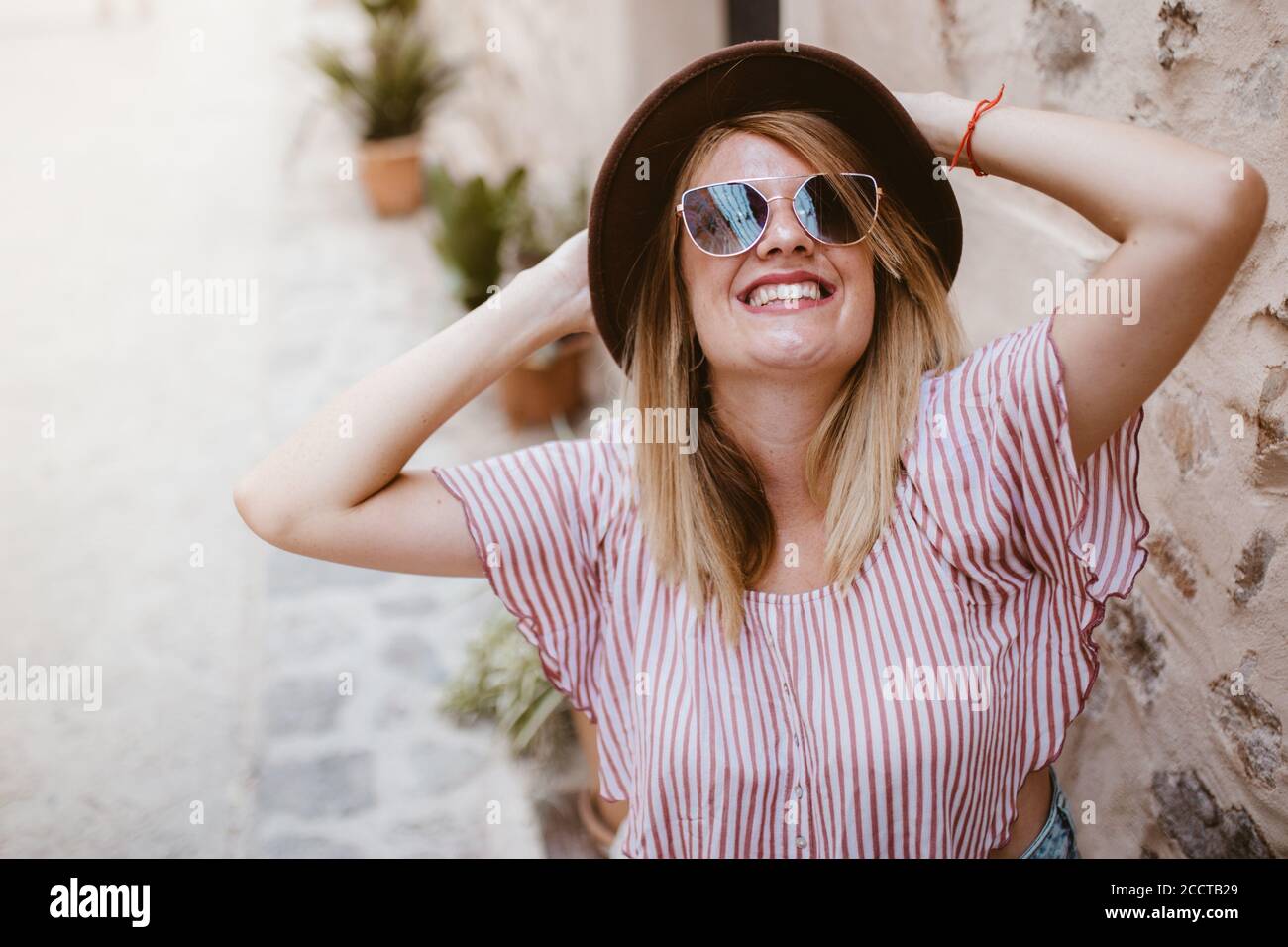 Young attractive smiling blond woman with hat joyfully Stock Photo