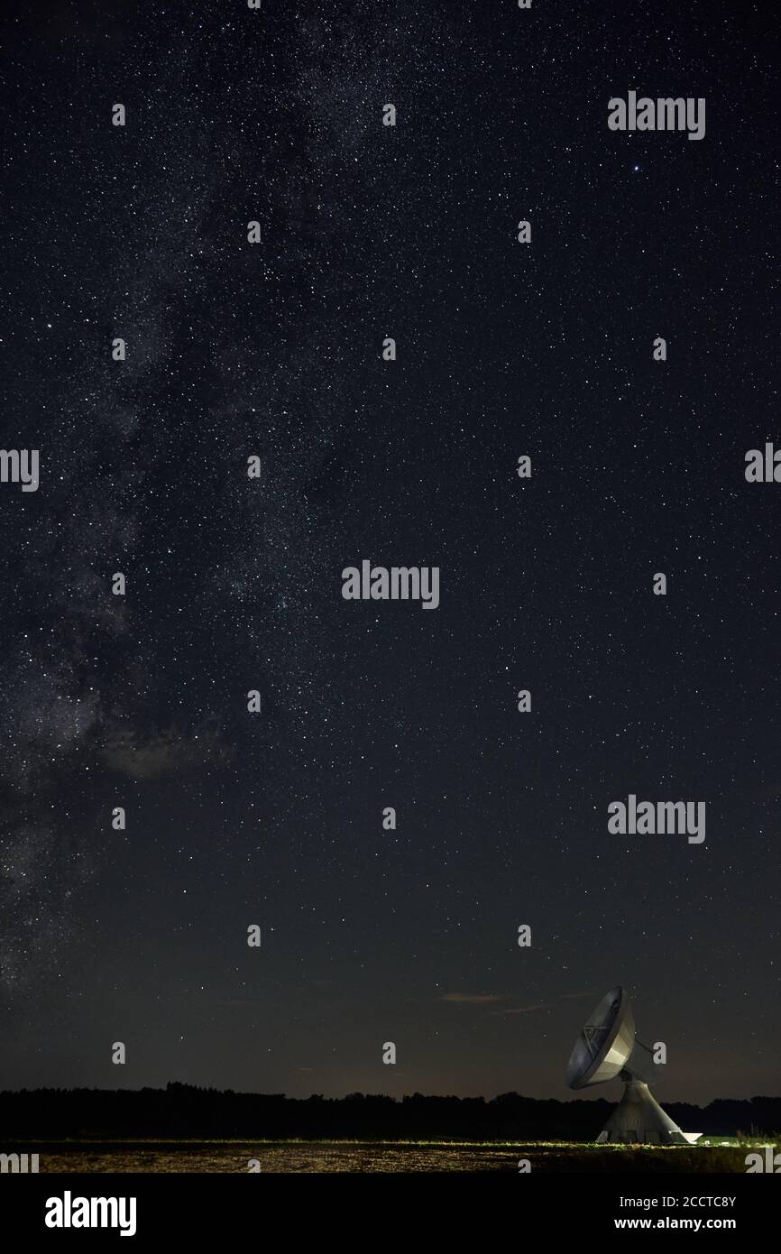 A dish antenna under a clear night sky and the milky way Stock Photo