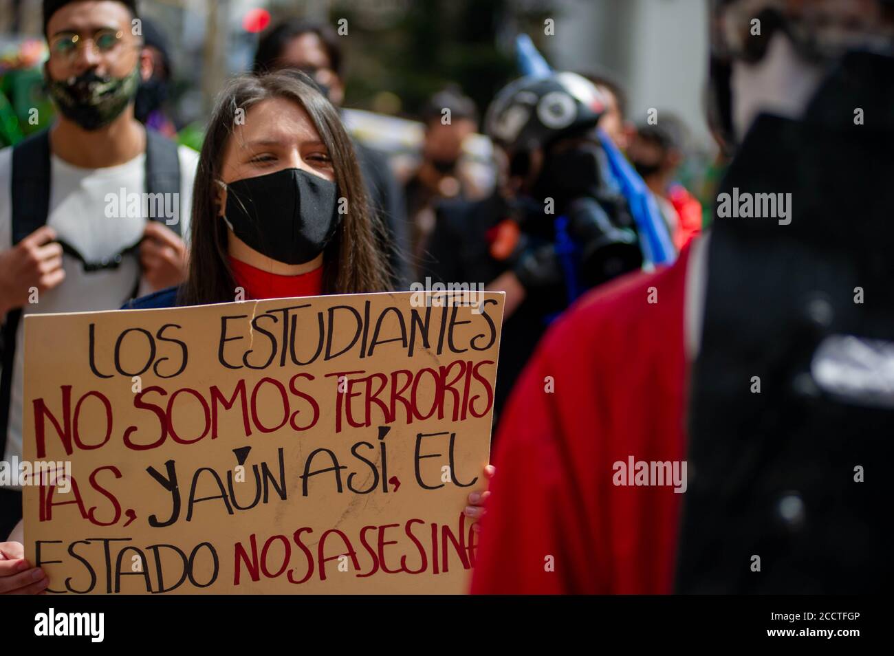 Bogota, Colombia. 23rd Aug, 2020. A demonstrator, holds a sign that reads in spanish 'Students aren't terririst but the goverment kills them' in front of the Supreme Court Palace on August 23 2020 in Bogota, Colombia. Dilan Cruz was a high school student who was shot by a riot police officer during the 2019 national strike in Colombia, on the demonstrations that took place on november 23 2019. (Photo by Sebastian Barros Salamanca/Pacific Press/Sipa USA) Credit: Sipa USA/Alamy Live News Stock Photo