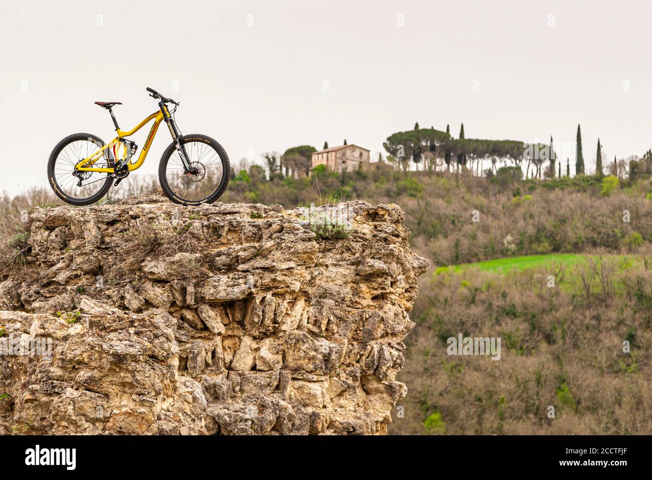 Mountain bike parked on a rocky peak in Bagno Vignoni, Val d'Orcia, Italy Stock Photo