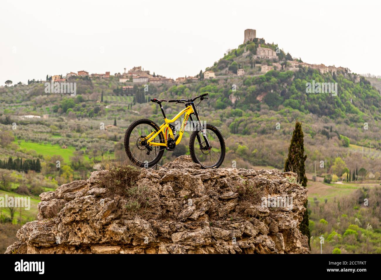 Mountain bike parked on a rocky peak in Bagno Vignoni, Val d'Orcia, Italy Stock Photo