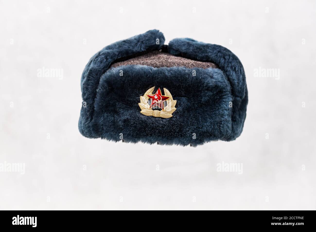 Soviet winter hat with pin badge on light background Stock Photo