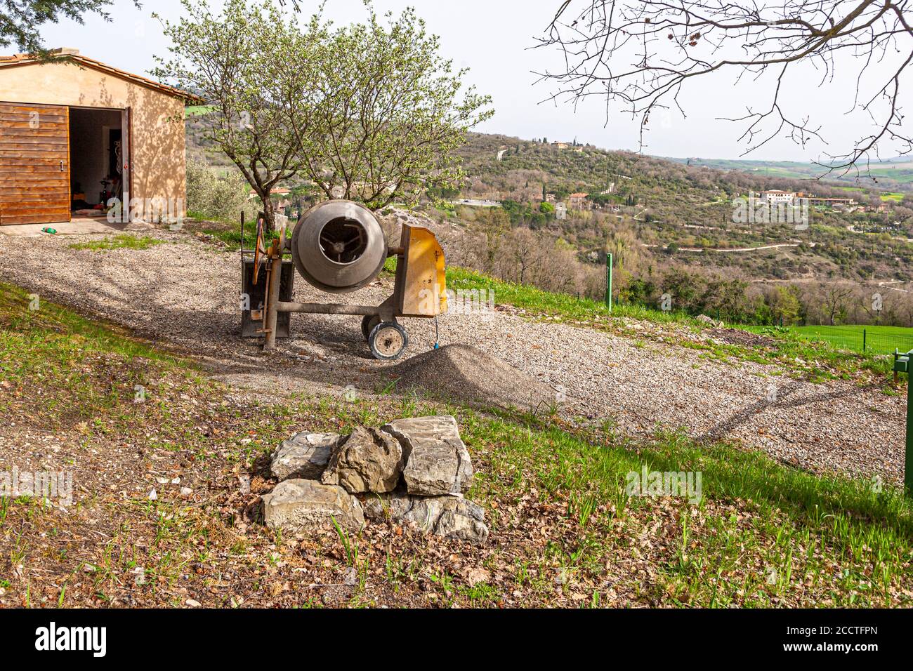 Cement mixer in an Italian garden. Bagno Vignoni, Val d'Orcia, Italy Stock Photo