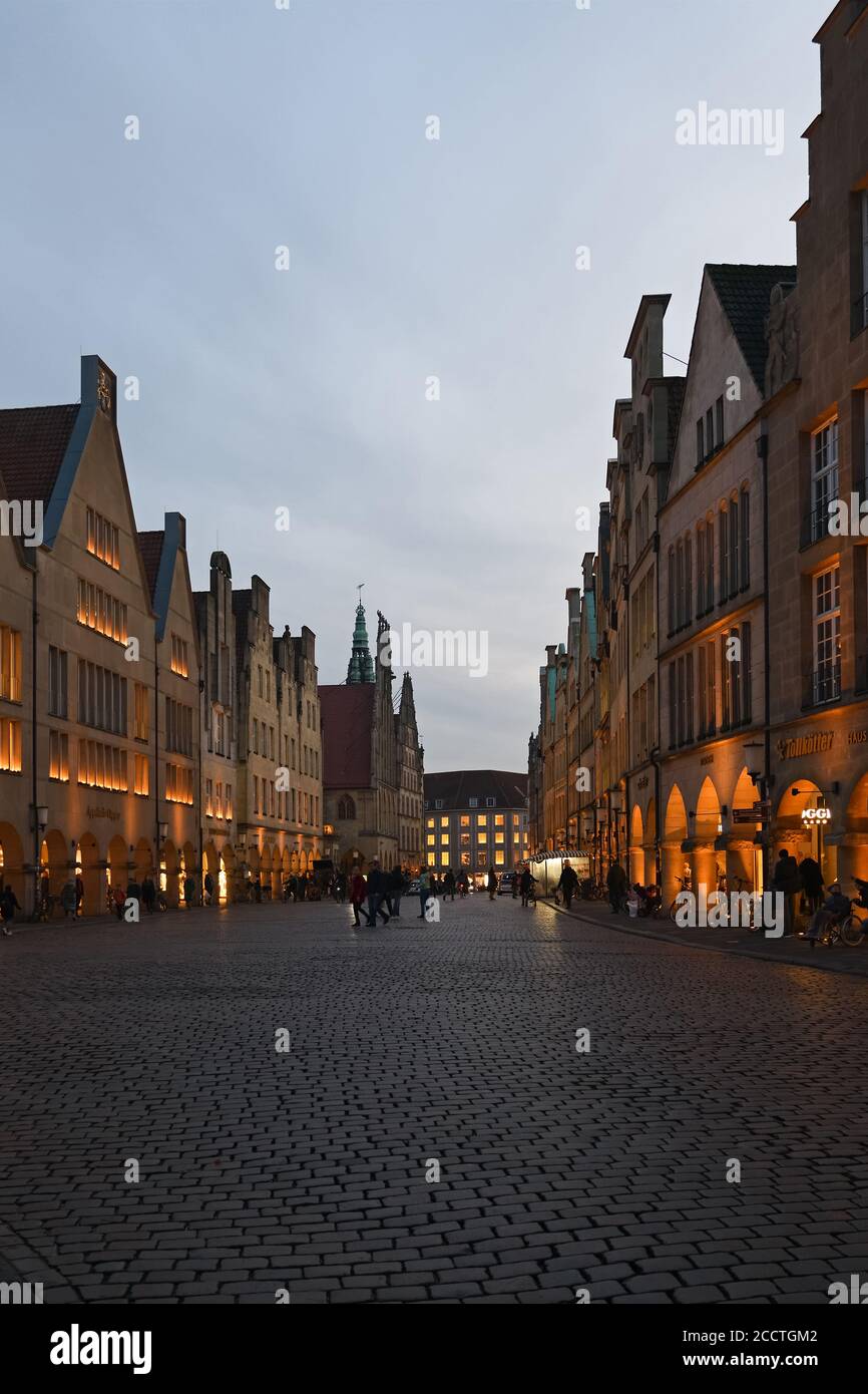 Muenster, Prinzipalmarkt at dusk, blue hour, illuminated gabled houses, luxury shopping street, view over ancient cobblestone road, Germany, Europe. Stock Photo
