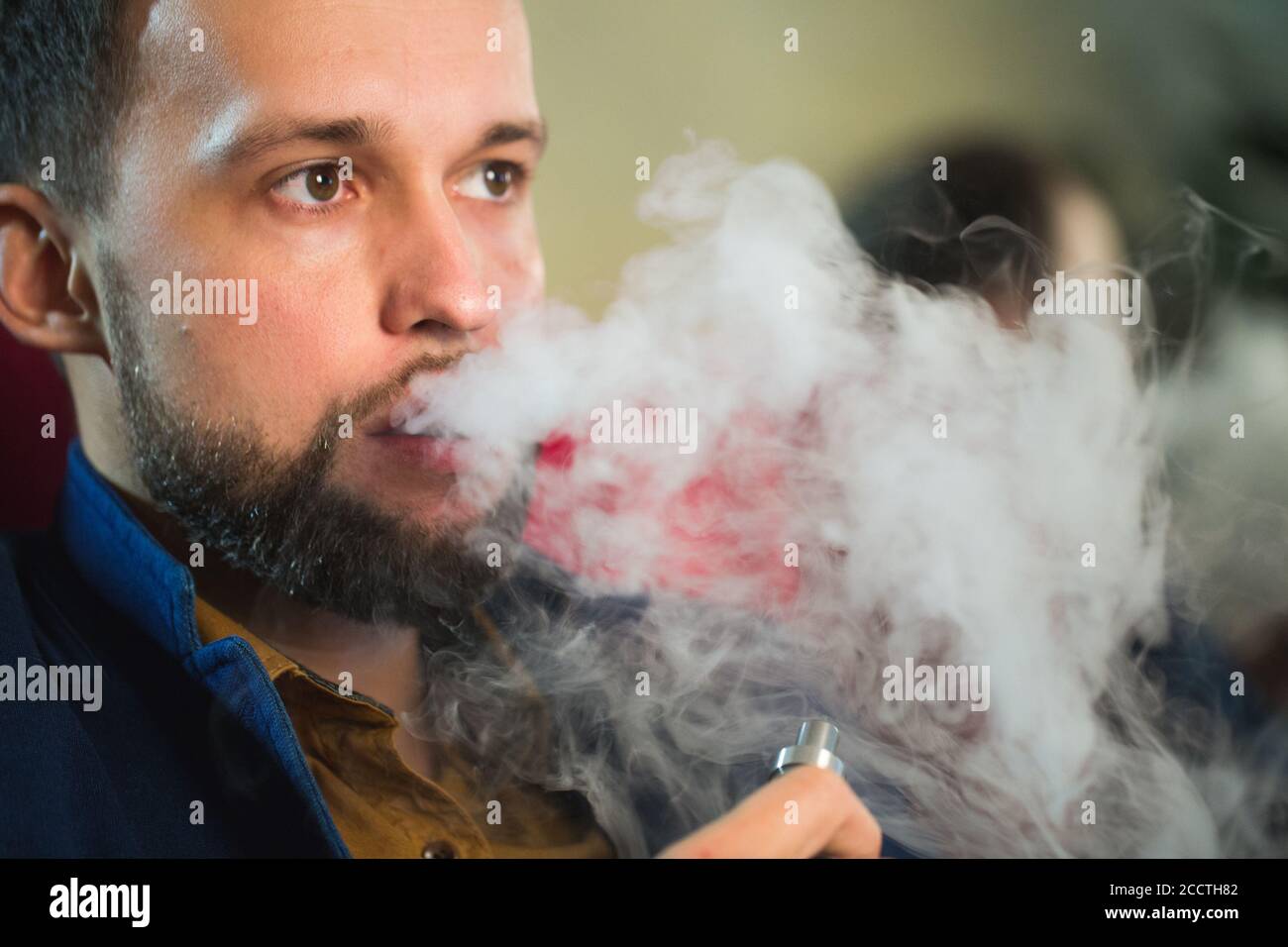 Smoking hookah. Man is blowing smoke in a cafe. Stock Photo