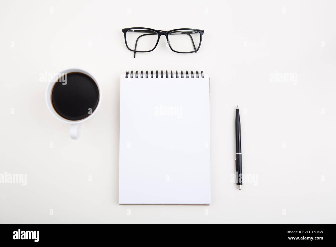 White notepad with black pen and glasses on light table, Stock Photo