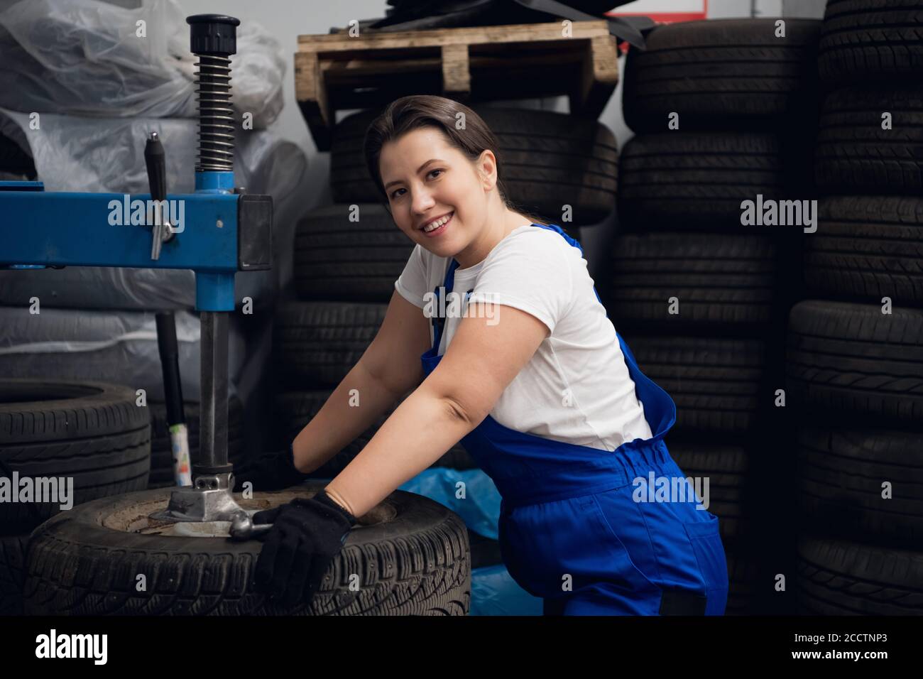 Worker at the workshop is using a press and looking at the camera Stock Photo