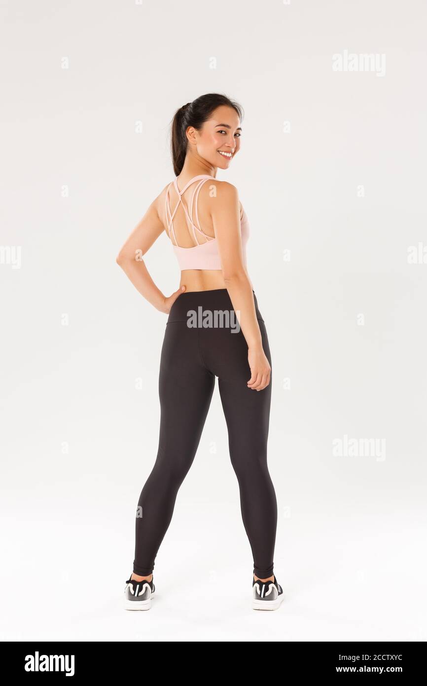 Full length of smiling slim and strong female fitness coach, female athelte  in sportswear turn behind to look at camera with pleased, motivated Stock  Photo - Alamy