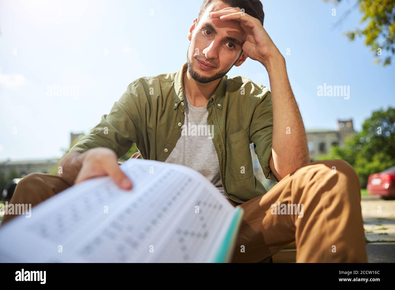 Undergraduate sitting with his head propped on his hand Stock Photo - Alamy