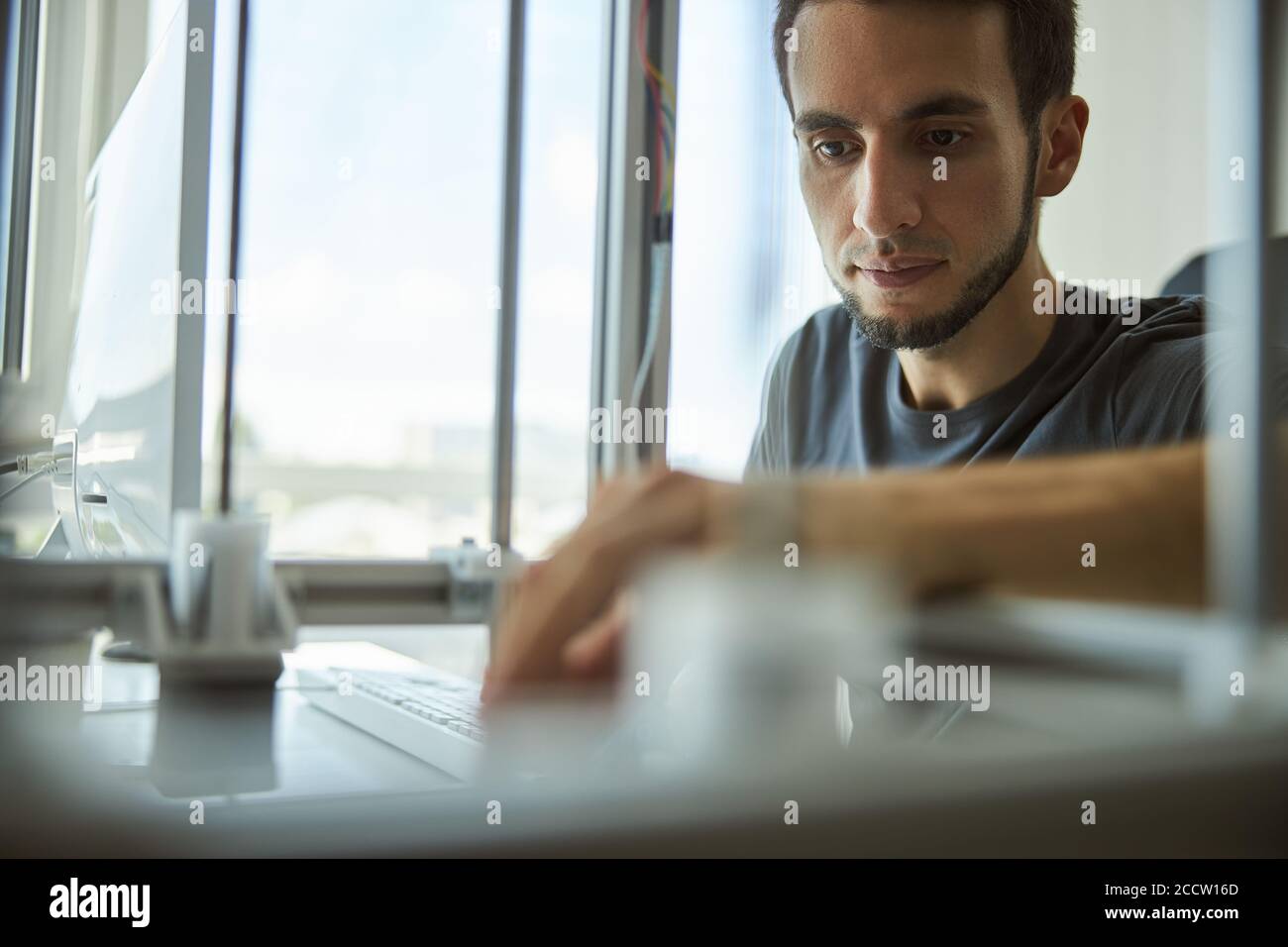 Focused male scientist using a 3D printer Stock Photo