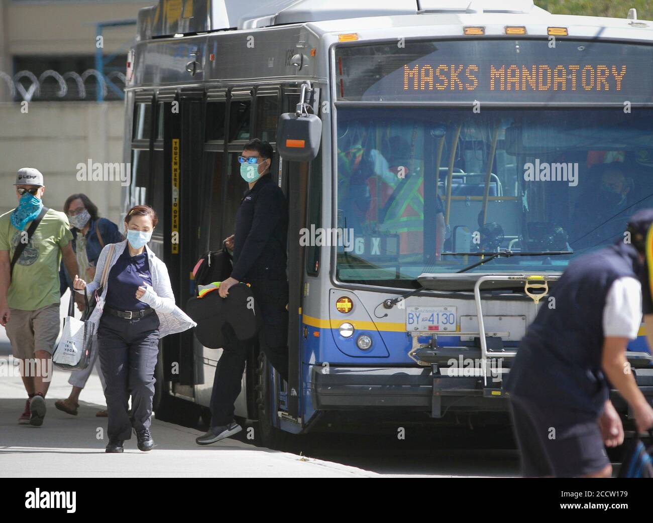 Vancouver, Canada. 24th Aug, 2020. People wearing face masks get off a bus in Vancouver, British Columbia, Canada, on Aug. 24, 2020. Anyone on board a TransLink or British Columbia (BC) Transit bus, boat or train and passengers on board BC Ferries vessels are required to wear a face mask beginning Monday to help stop the spread of COVID-19. Credit: Liang Sen/Xinhua/Alamy Live News Stock Photo