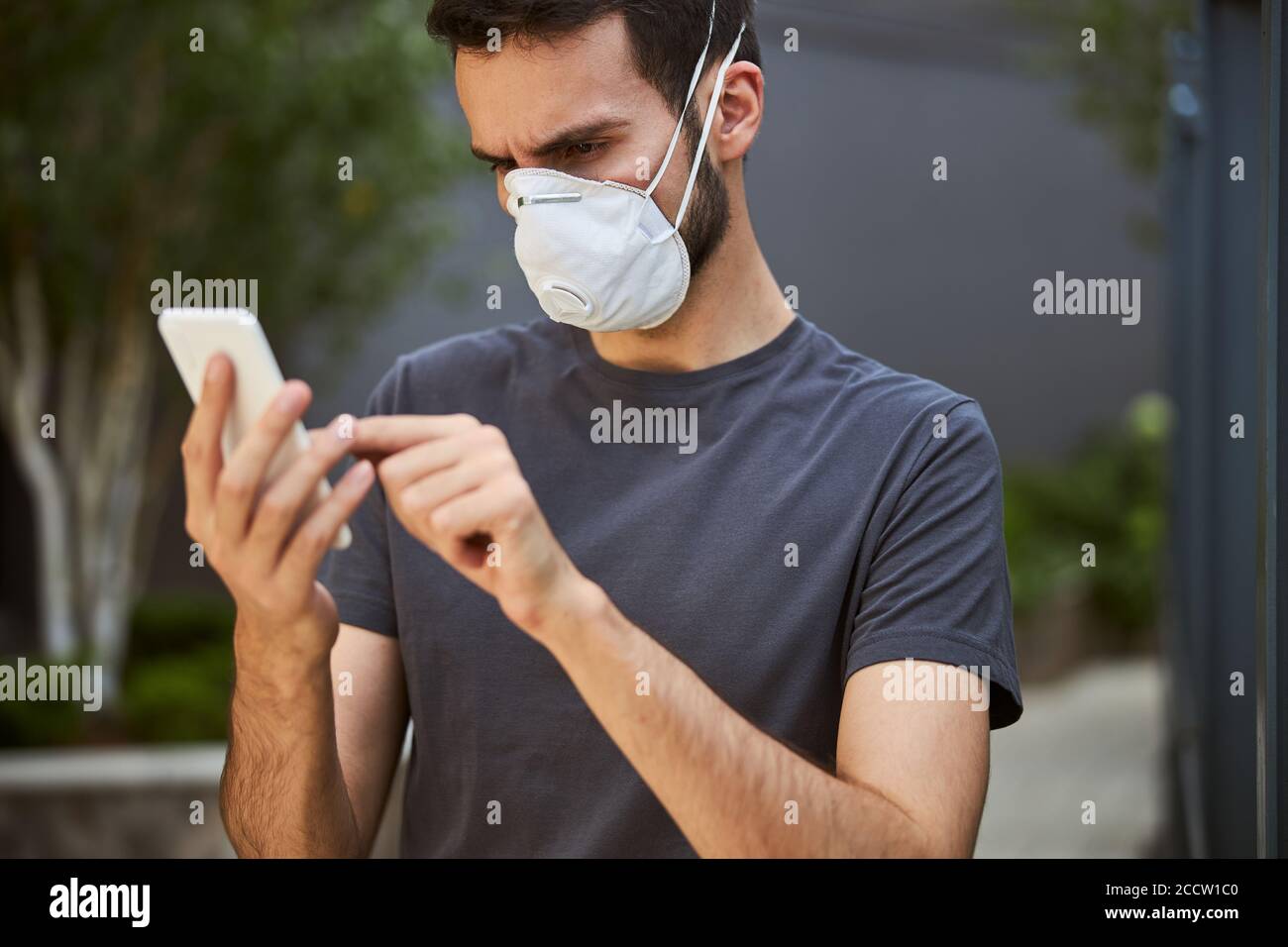 Focused man staring at his gadget outdoors Stock Photo