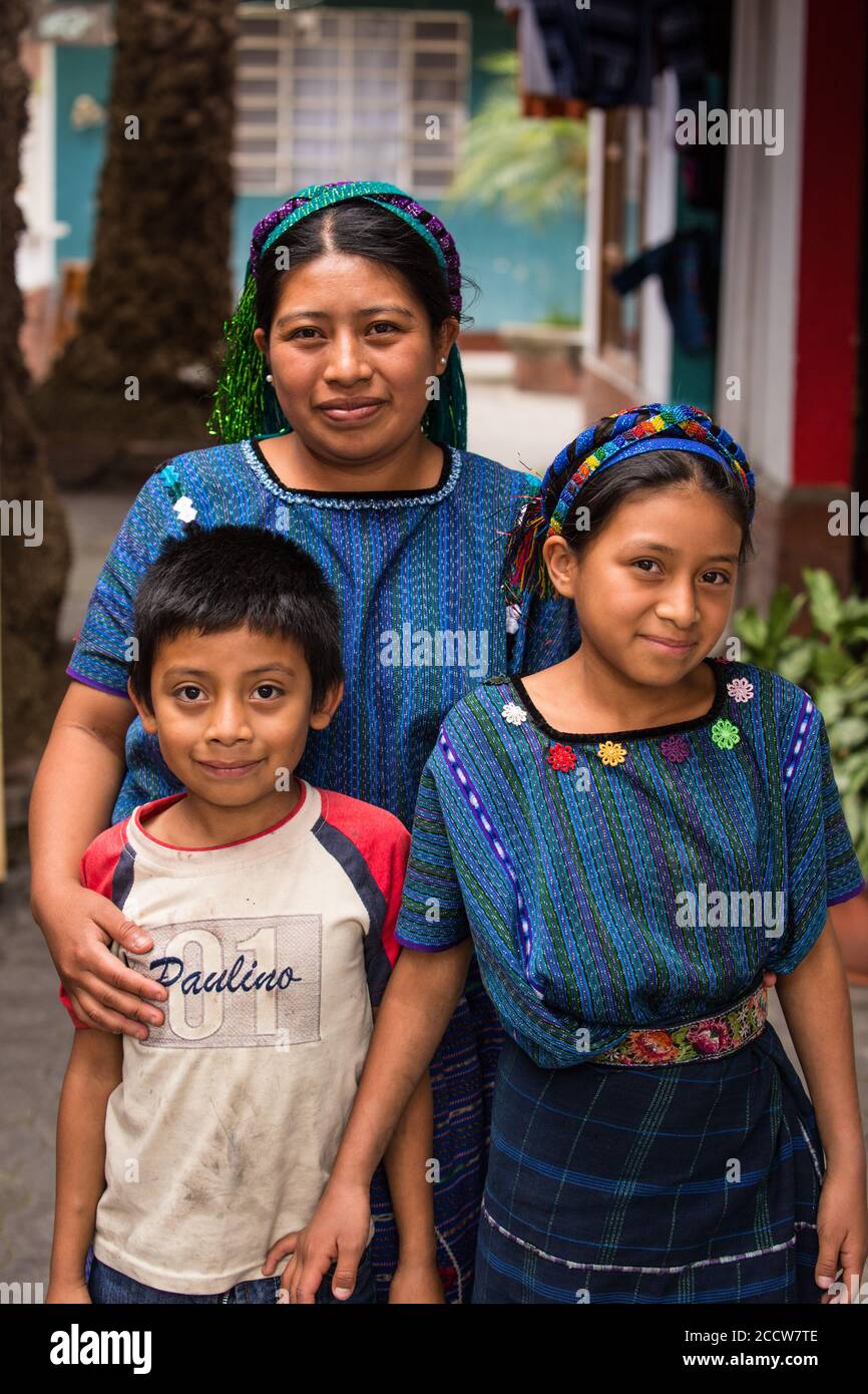 A Cakchiquel Mayan woman in traditional dress from San Antonio Palopo, Guatemala, with her children.  Her blue woven huipil blouse is characteristic o Stock Photo