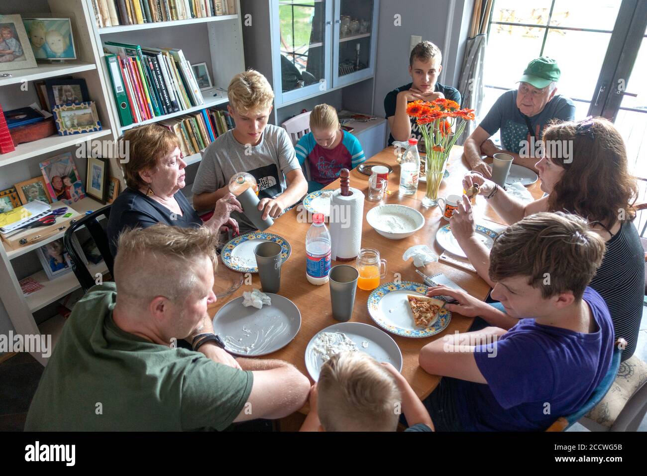 Polish family of three generations gathered around the dinner table enjoying home cooked pizza together. Zawady Gmina Rzeczyca Poland Stock Photo