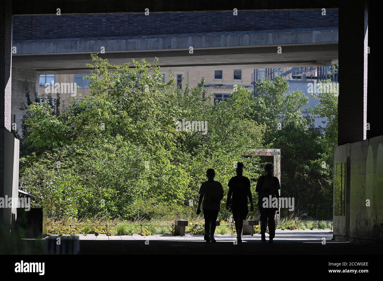 New York City, USA. 24th Aug, 2020. Three people walk under the Standard Hotel that is build over the The High Line Park, New York, NY, August 24, 2020. The High Line Park recently reopened to visitors with several restrictions including signing up for a window of time spaced at 15minutes, entrance only through Gansevoort Street, traveling only on a one-way path with social distancing markers and exiting at 23rd Street. (Anthony Behar/Sipa USA) Credit: Sipa USA/Alamy Live News Stock Photo