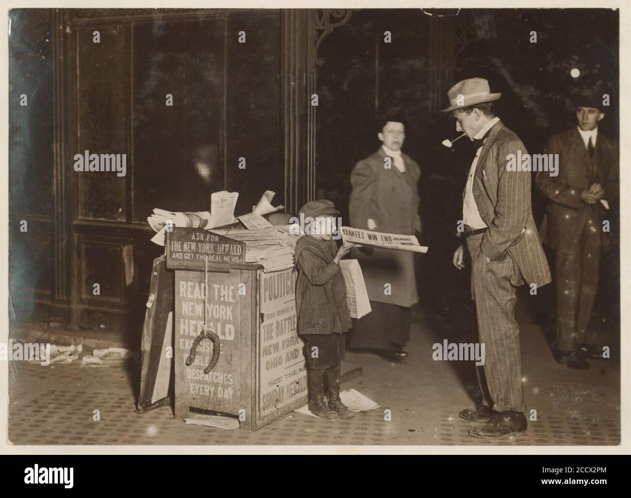 Jerald Schaitberger of 416 W. 57th St. N.Y. who helps an older boy sell papers until 10 P.M. on Columbus Circle. 7 yrs. old. 9-30 P.M., October 8, 1910. Stock Photo