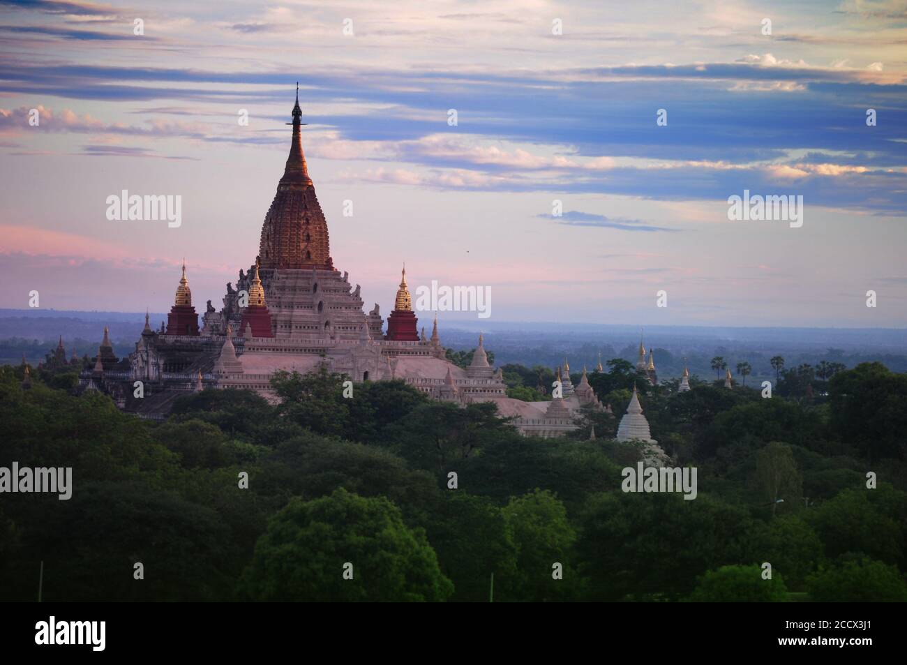 The aerial view of Ananda Temple in Old Bagan surrounded by lush trees and sky background Stock Photo