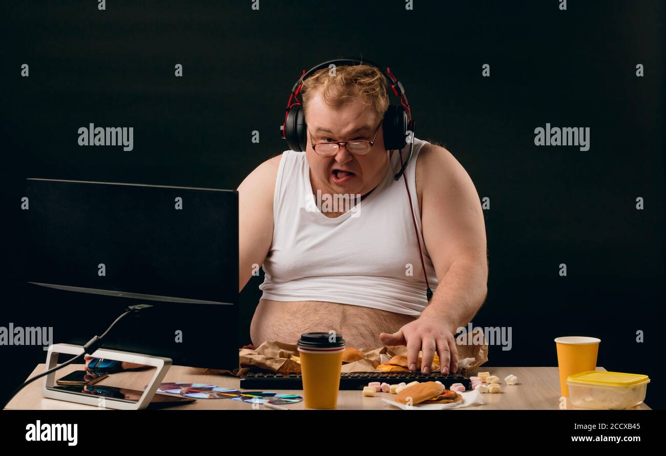 funny man is crazy about computer games and fast food. close up photo