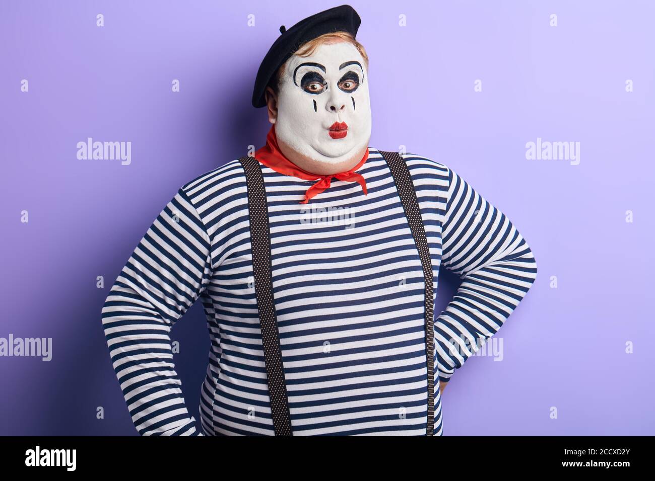awesome man with painted face amusing audience. close up photo. isolated blue backround, studio shot. Stock Photo