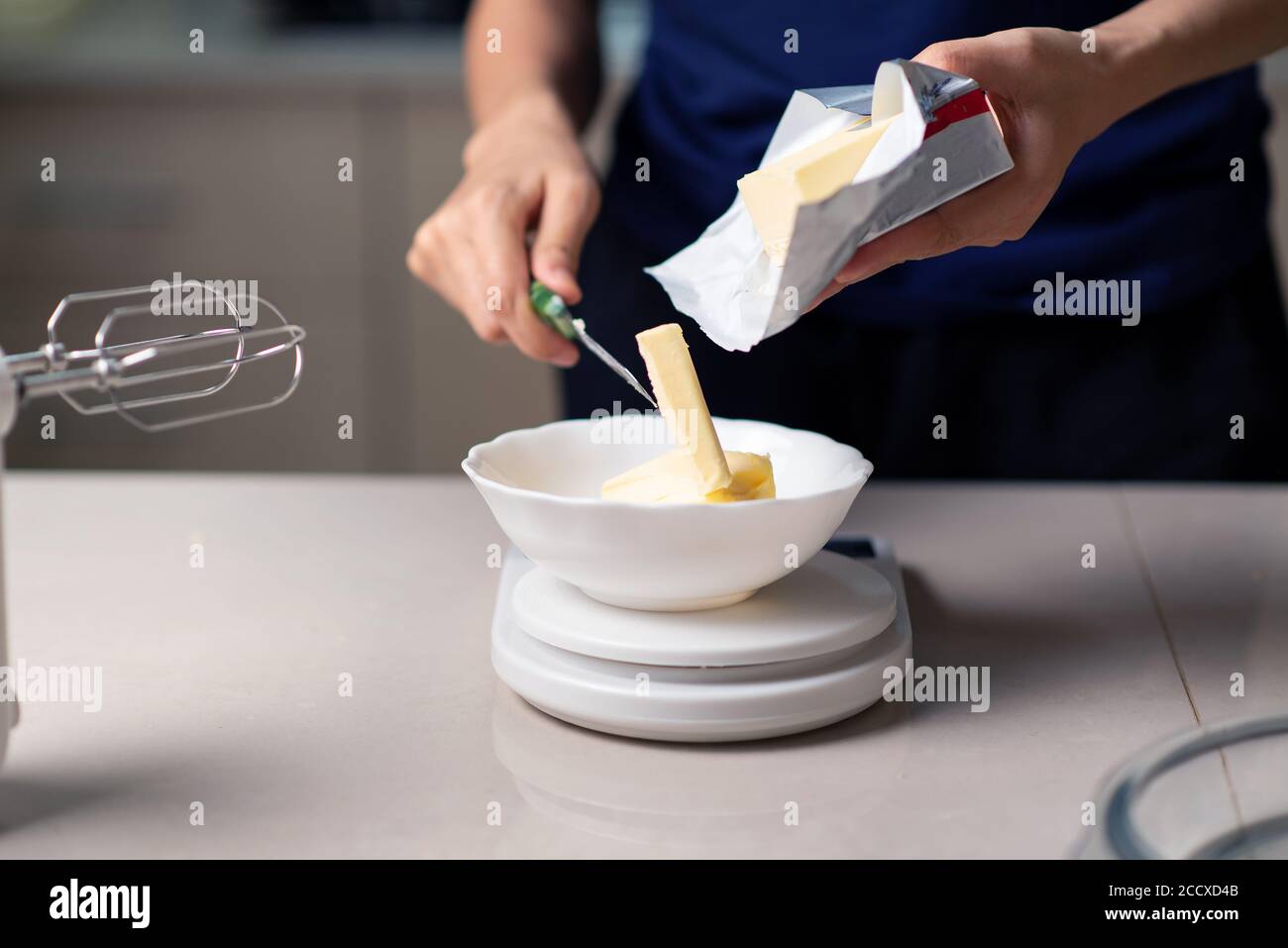 https://c8.alamy.com/comp/2CCXD4B/woman-measuring-butter-on-a-small-kitchen-scale-while-making-cookies-in-the-kitchen-at-home-closeup-2CCXD4B.jpg