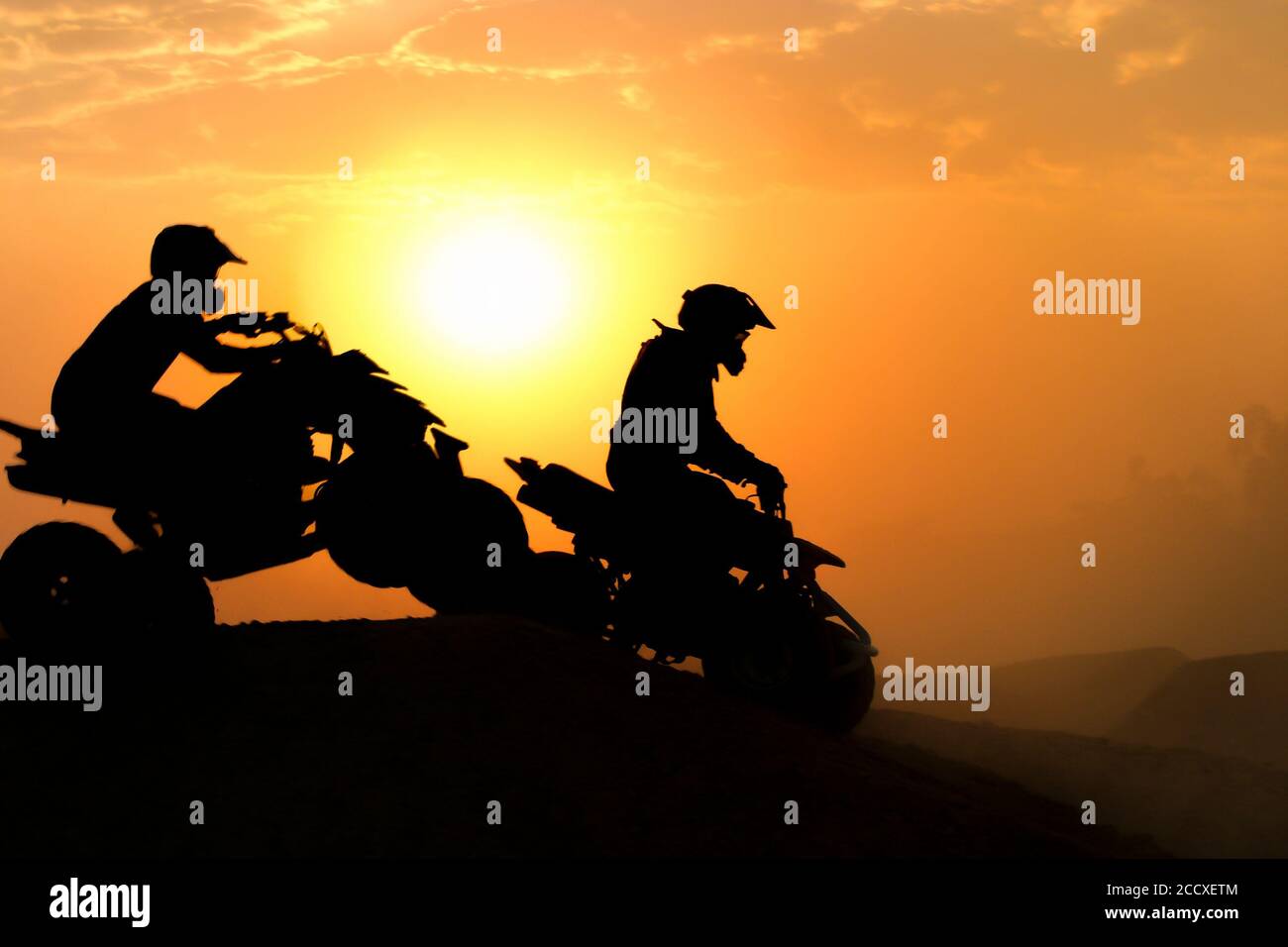 Silhouette ATV or Quad bikes Jump in the sunset. Stock Photo