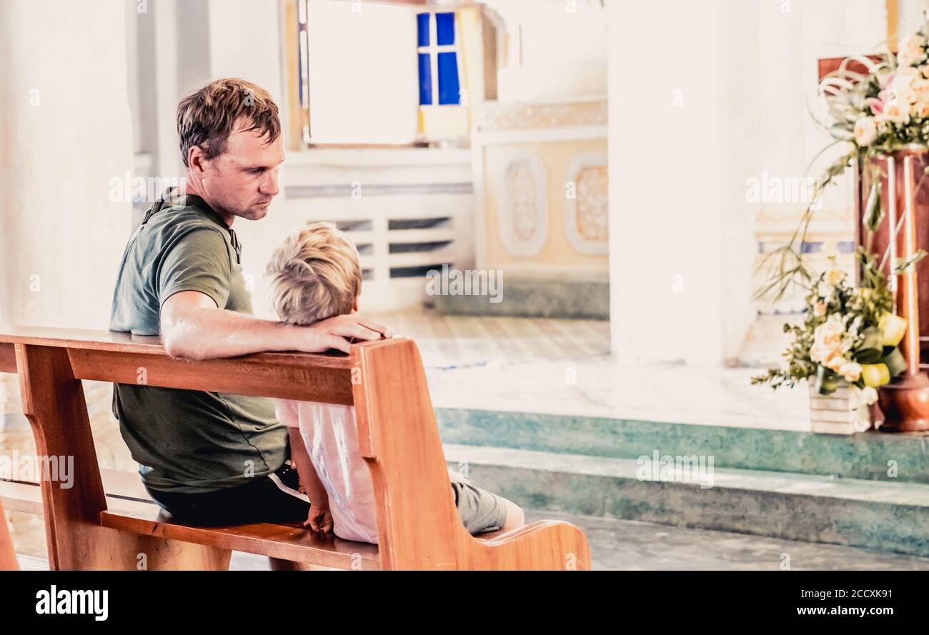 Christian dad tells his son Bible stories about Jesus sitting in kirk ...