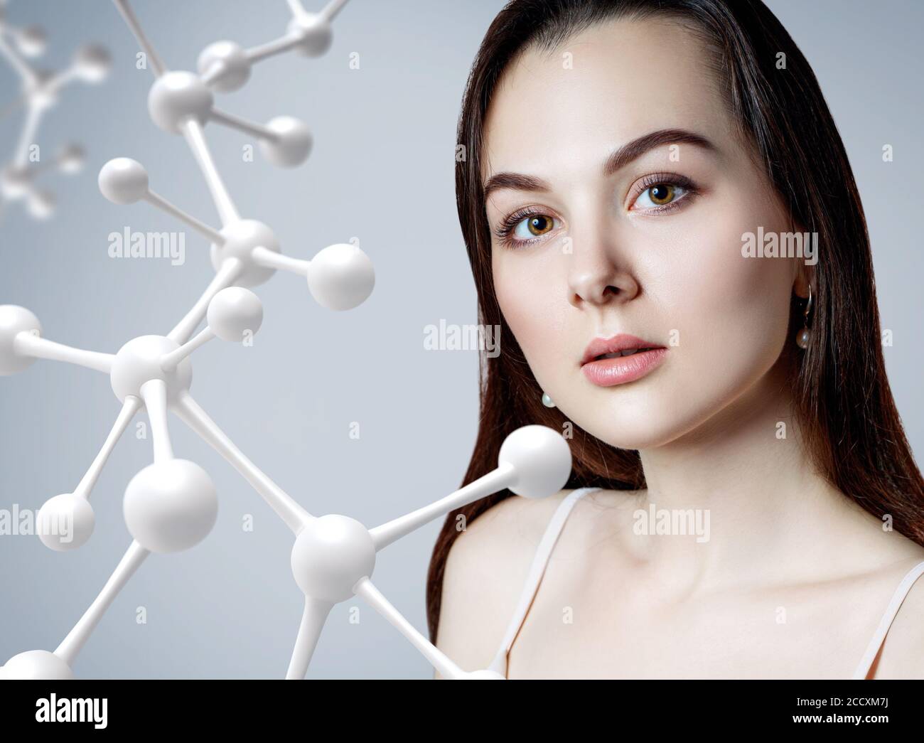 Beautiful woman near big white molecule chain. Stock Photo