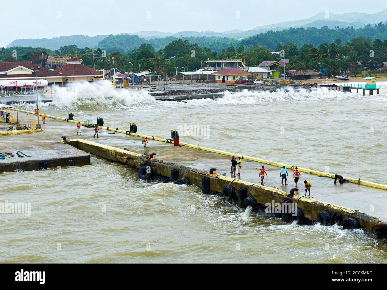 Caticlan pier, Aklan, Philippines: Very rough sea with big waves at the gateway to Boracay Island. Porters preparing for docking. Stock Photo