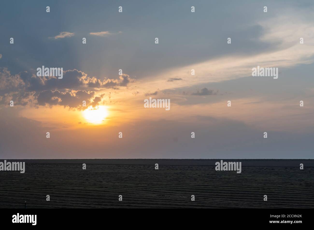 dark landscape of evening cloudy sunset on the background of an agricultural field Stock Photo