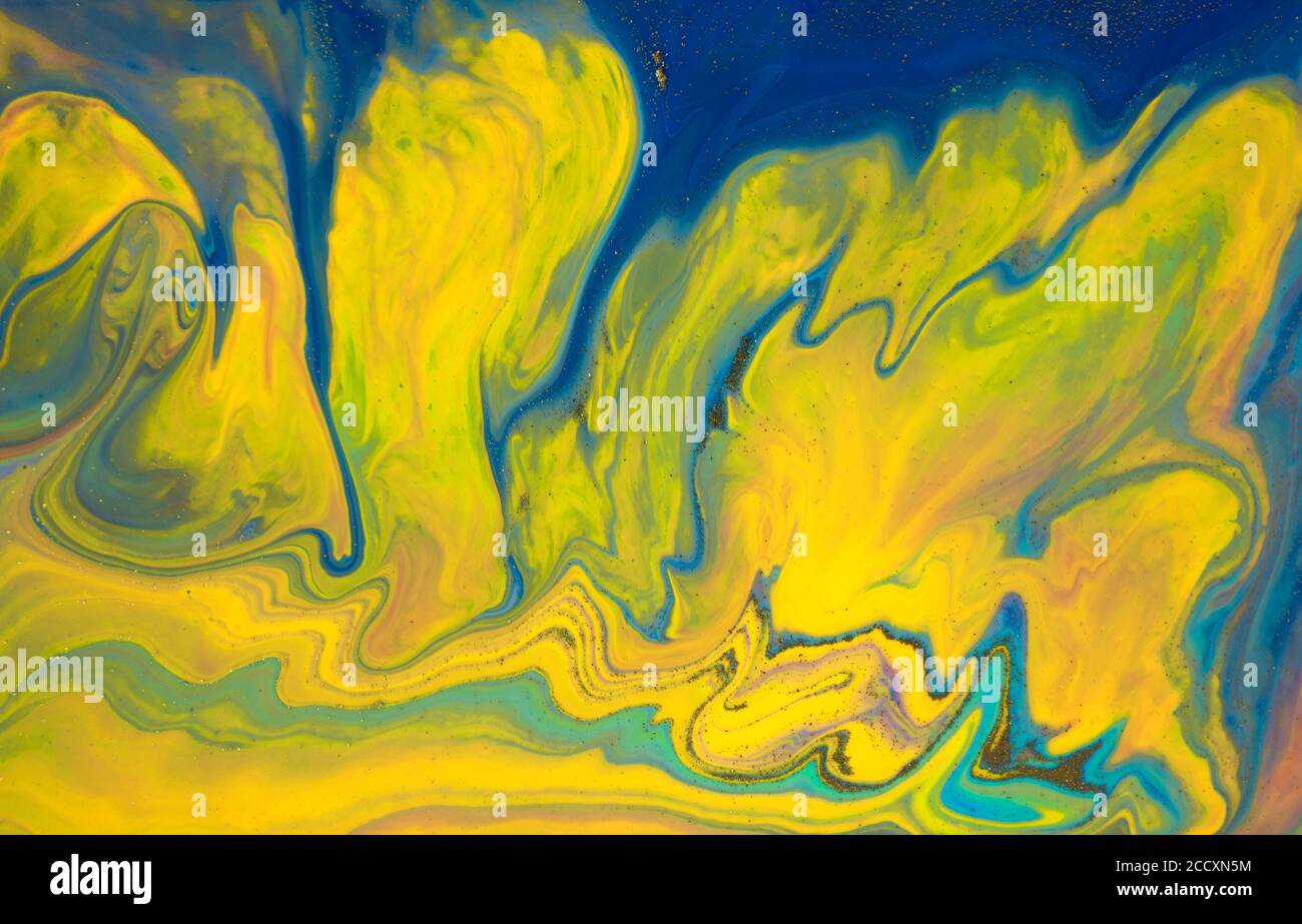 Liquid yellow and blue abstract texture. Art technique. Smudges of acrylic bright colors. Mixed