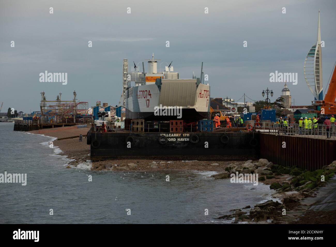 Portsmouth, Hampshire, UK. 24th Aug 2020. Workers prepare the LCT 7074, the last surviving amphibious landing craft tank, to be moved to the D-Day Museum in Portsmouth, Monday August 24, 2020.  The craft which originally carried tanks and soldiers to Normandy, was floated by barge from the National Museum of the Royal Navy, where it was being restored, to the Promenade in Southsea, where a crane built a bridge to the barge, so it could be driven to its new home at the D-Day Museum. Credit: Luke MacGregor/Alamy Live News Stock Photo