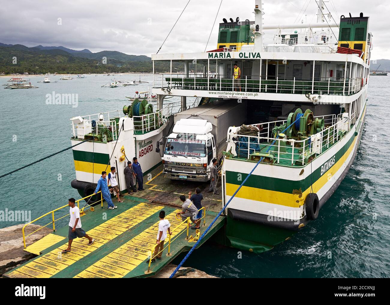 Caticlan pier, Aklan, Philippines: An inter-island vessel of Montenegro shipping lines docking at the harbor, trucks disembarking Stock Photo