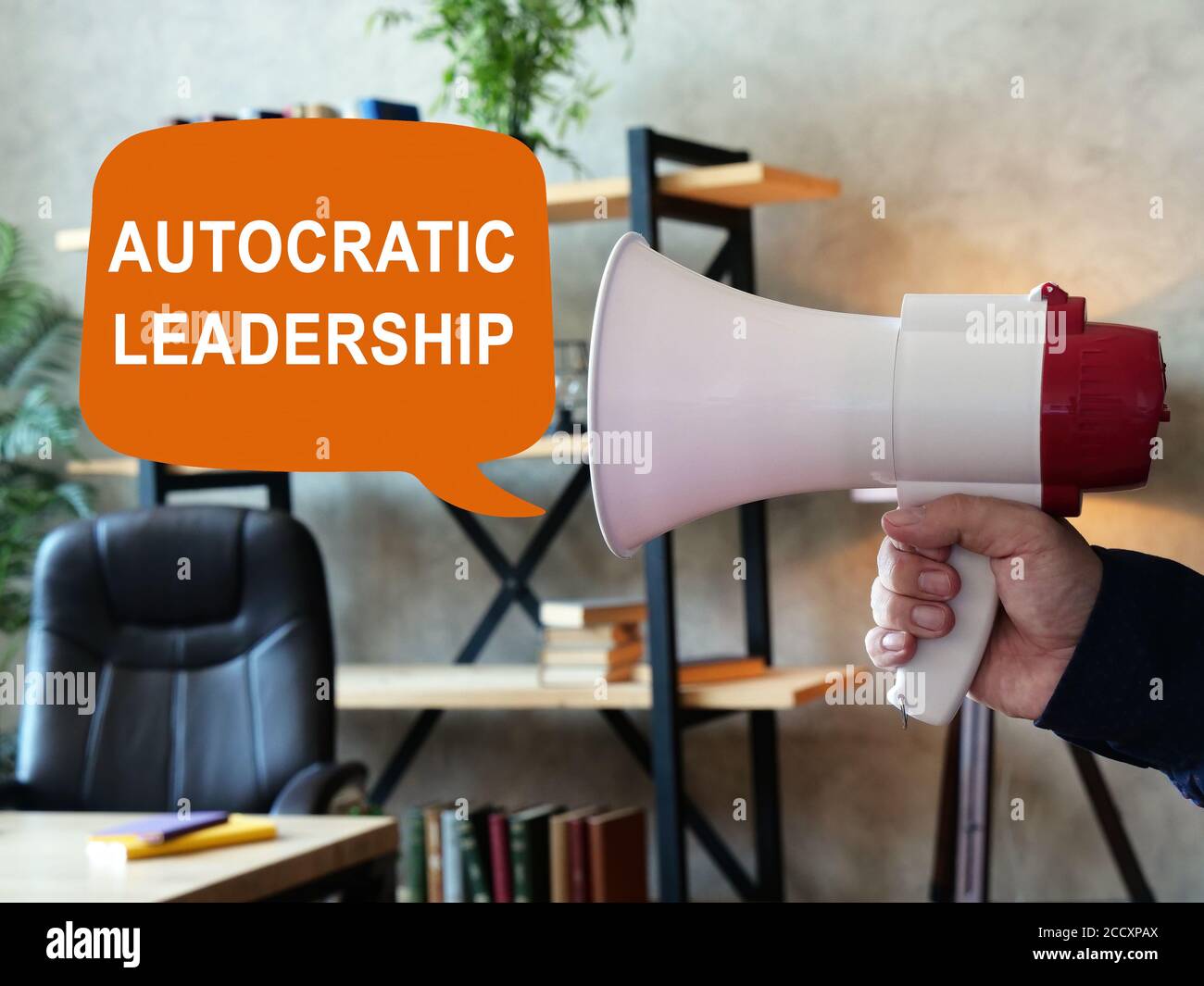 Autocratic leadership concept. Loudspeaker in hand and sign. Stock Photo
