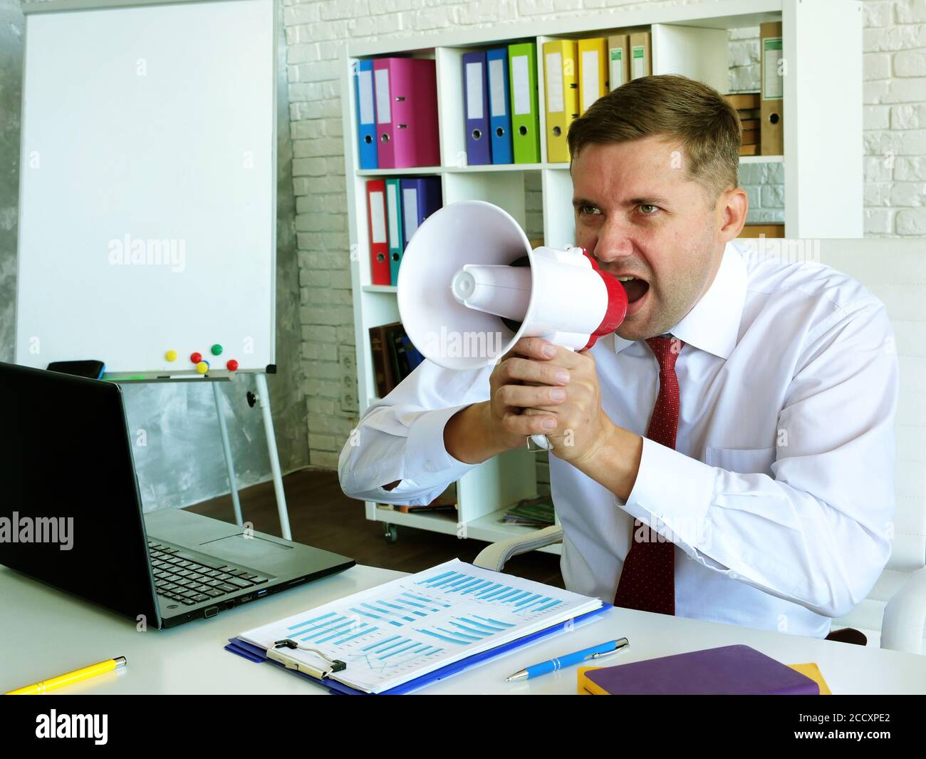 Thought and charismatic leadership. Boss with loudspeaker in the office. Stock Photo