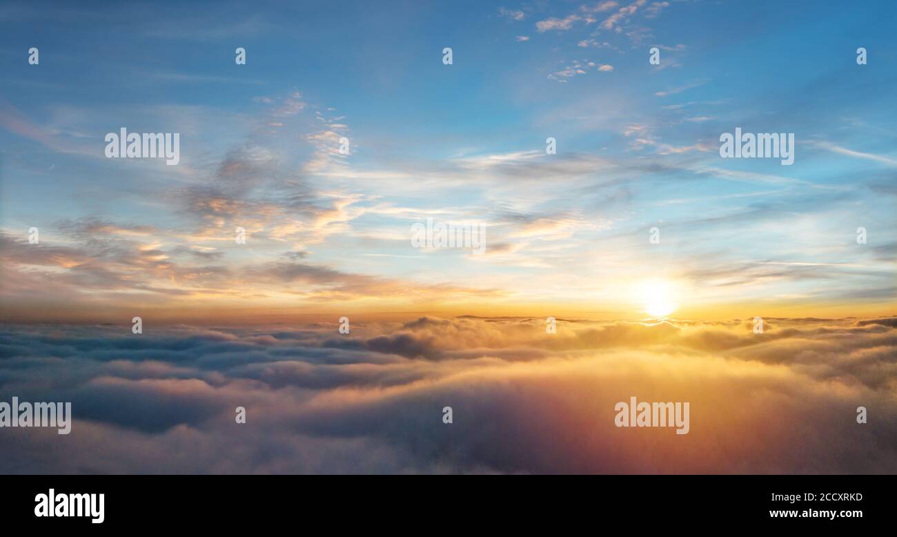 Beautiful aerial view above clouds with sunset. Airplane view Stock Photo