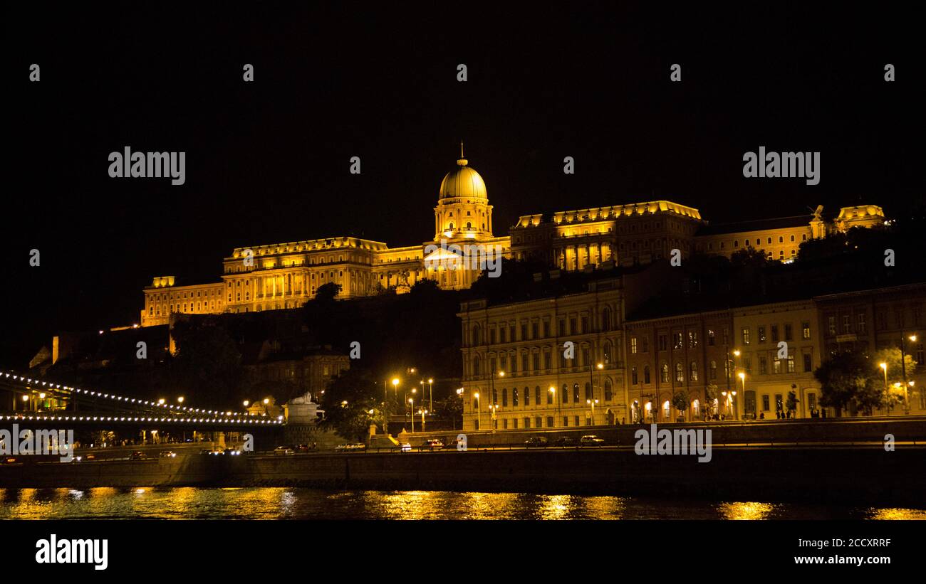 Eastern Europe, Hungary, Budapest, Royal Palace (Kiralyi palota) at night, The Danube River in the foreground Stock Photo