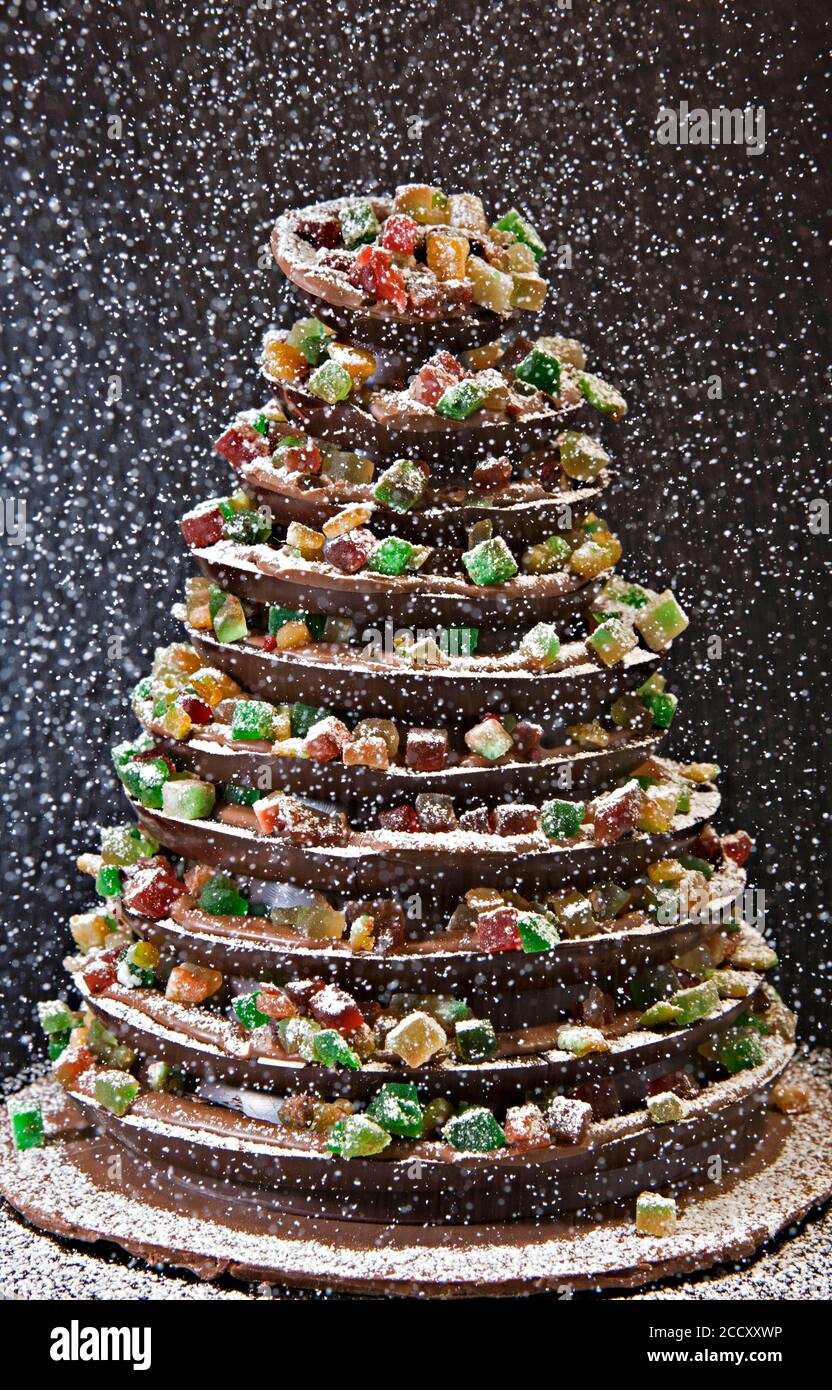 Icing sugar falls on traditional Christmas chocolate tree with fruits, Madrid, Spain Stock Photo