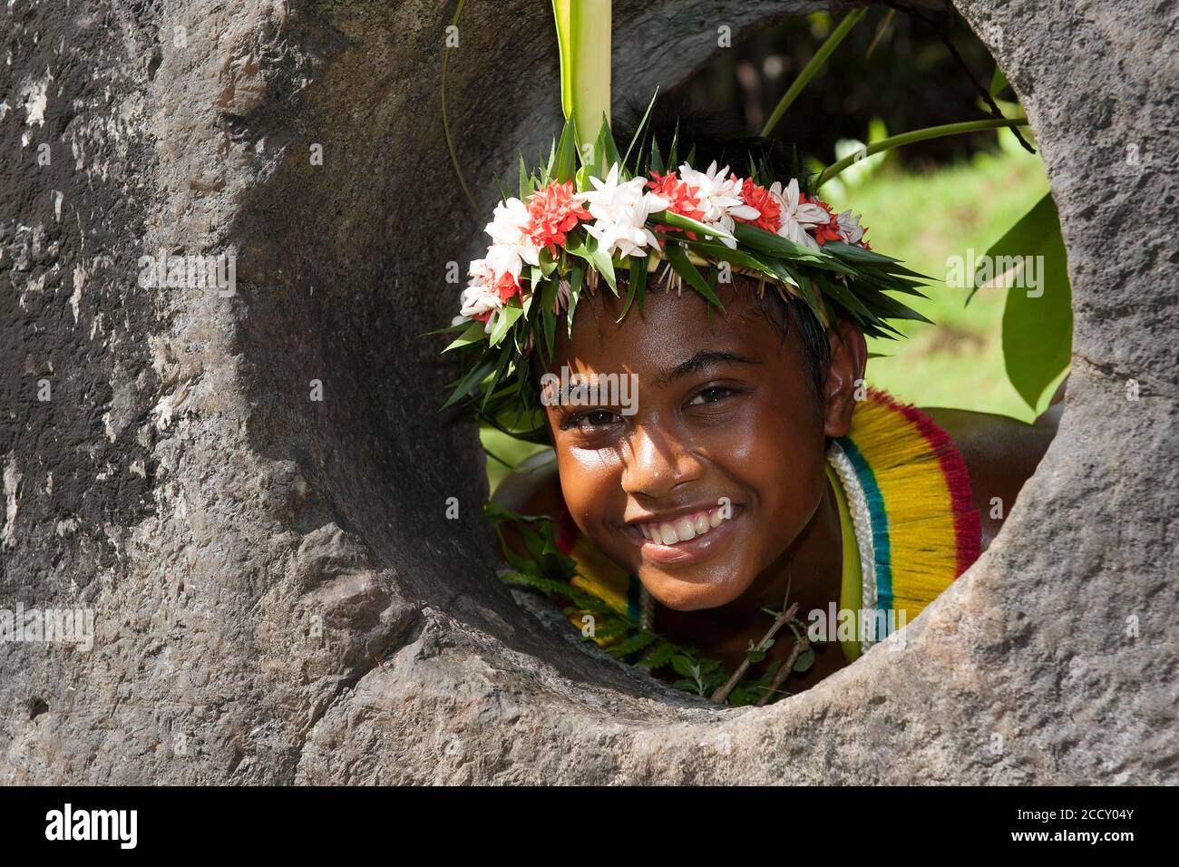 Native boy from Yap looks through stone money hole, stone money bank, Yap Island, Micronesia Stock Photo