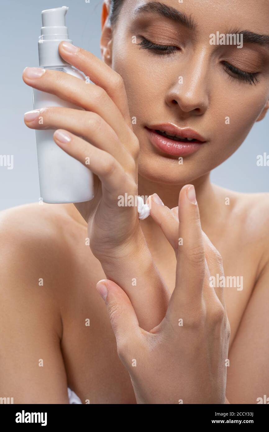 Concentrated Pretty Lady Using A Beauty Product Stock Photo Alamy