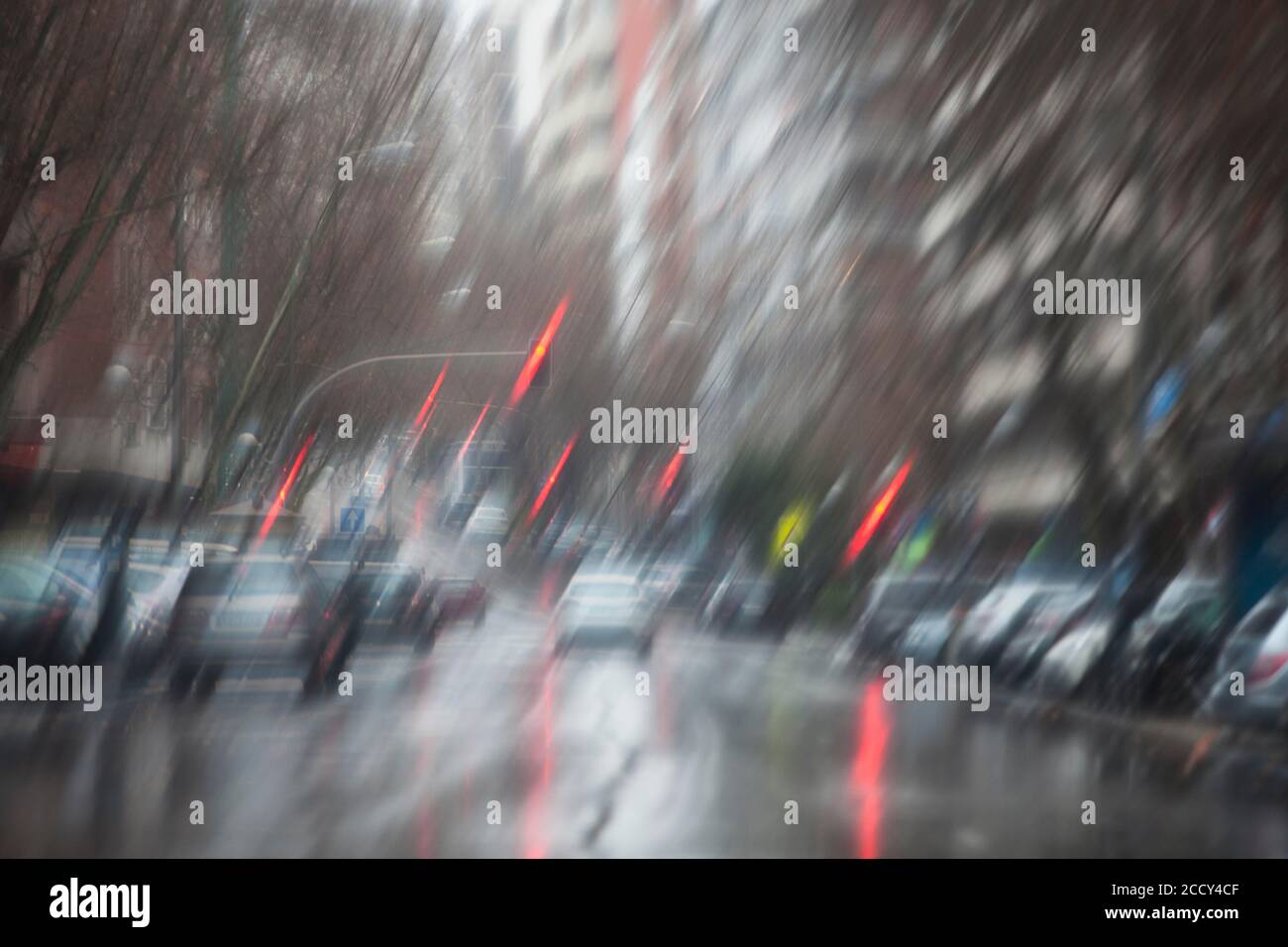 A blurry image of the street with cars and traffic lights taken from inside the car during a rainy day in Madrid Stock Photo