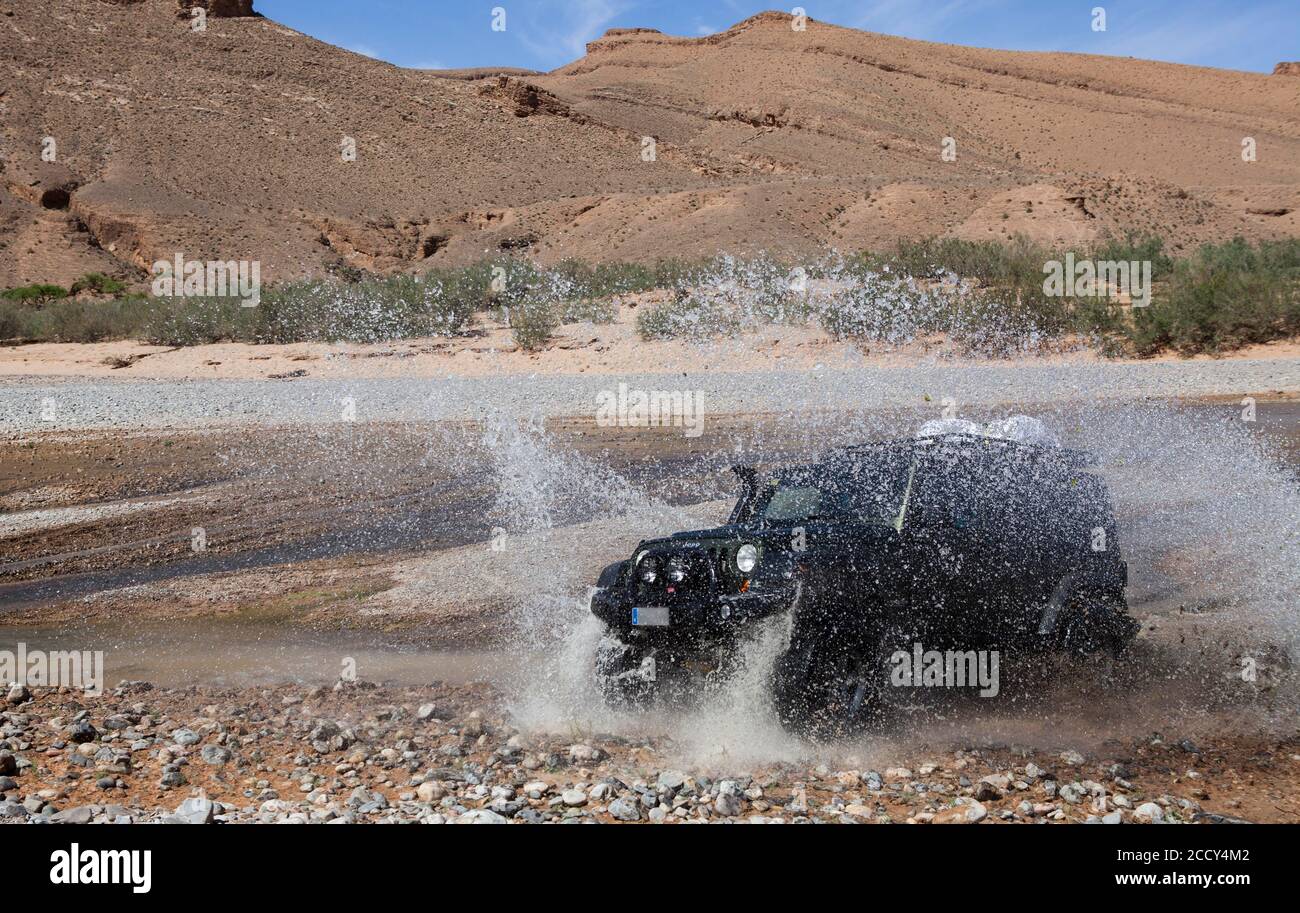 Off-road vehicle crosses a river in the Middle Atlas, Morocco Stock Photo