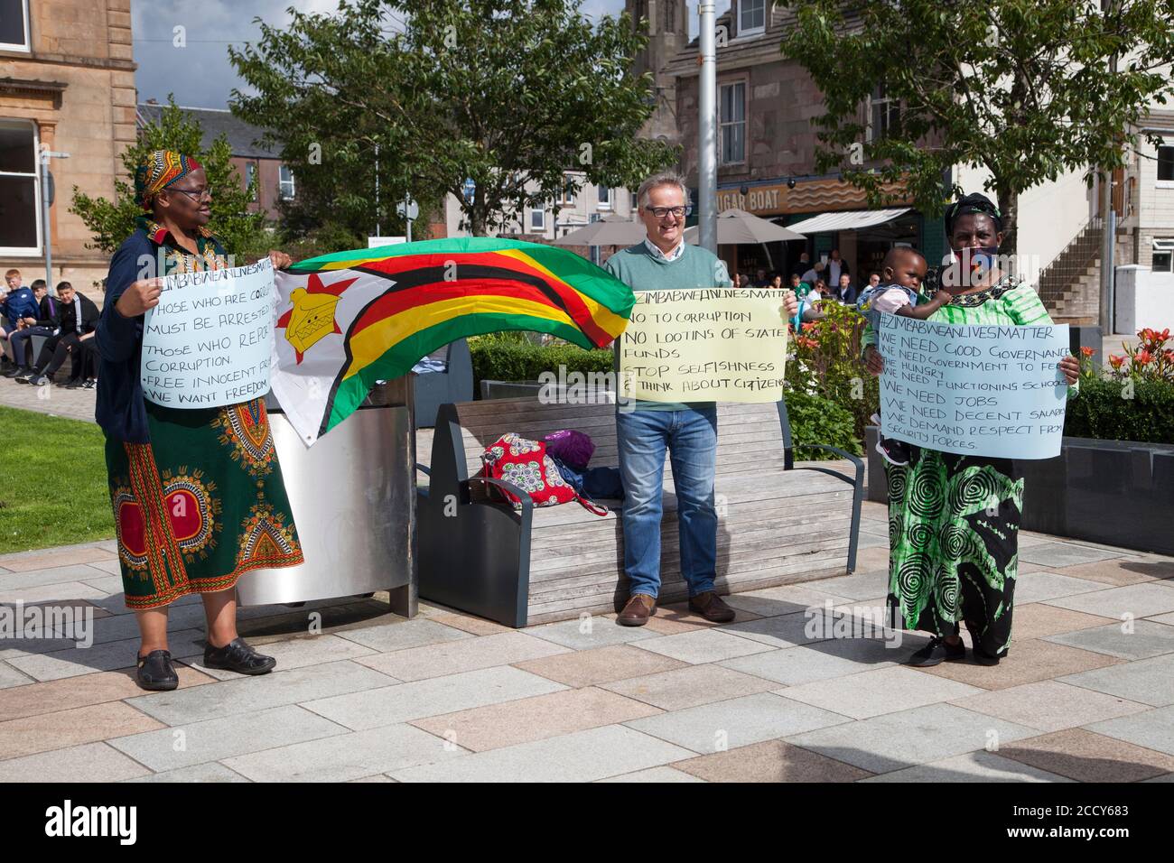 Supporters at the Zimbabwe lives matter protest at Helensburgh, Scotland with placards and flag. Stock Photo