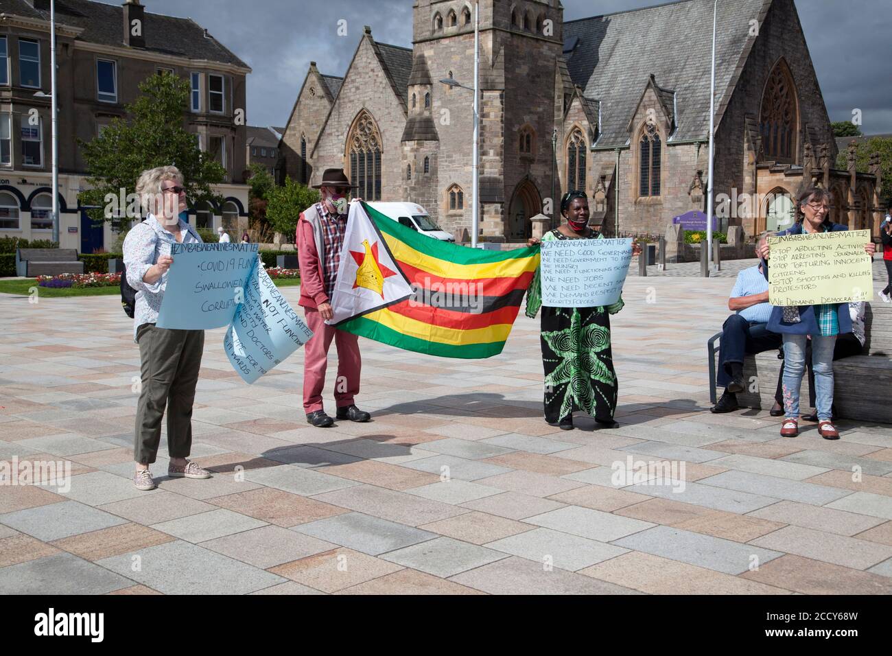 Supporters at the Zimbabwe lives matter protest at Helensburgh, Scotland with placards and flag. Stock Photo