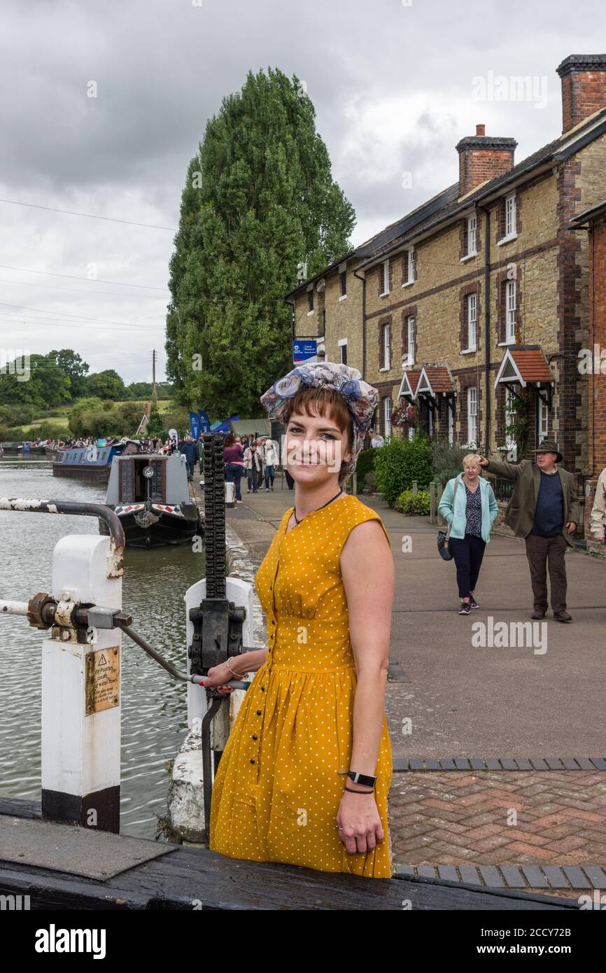 Girl in 40's dress with headscarf operating a canal lock at the Village at War event, Stoke Bruerne, Northamptonshire, UK Stock Photo