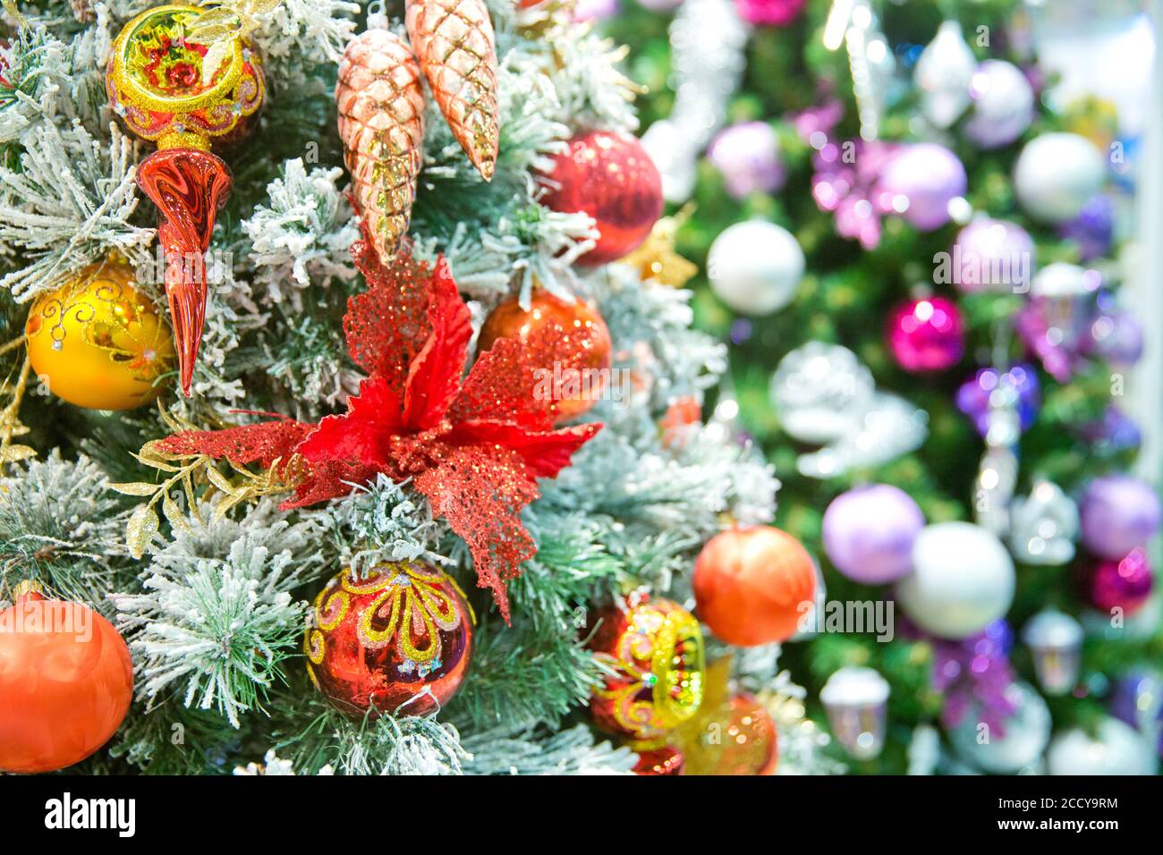 Decorated Christmas tree on blurred, sparkling and fairy background. Close up of colorful ornaments on Christmas tree. Happy New Year and Christmas. Bokeh light soft effect. Stock Photo