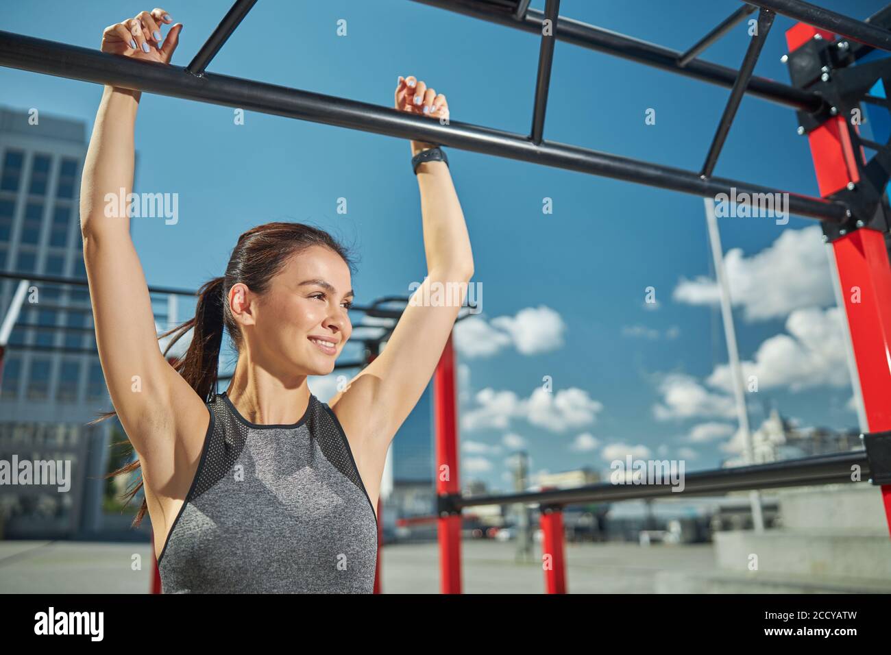 Positive delighted woman pulling up on the bar Stock Photo