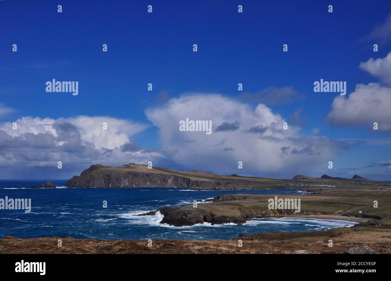 View from Clogher head towards Sybil Head on the coastal path towards the Three Sisters with a choppy Atlantic ocean hitting the rocks and Clogher bea Stock Photo