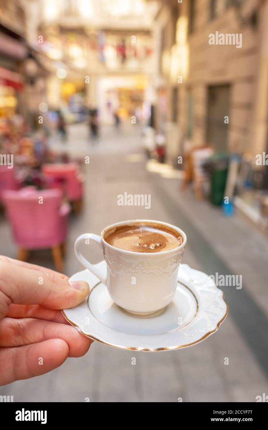 Mens hand holding cup of the traditional Turkish coffee close-up in Istanbul Stock Photo